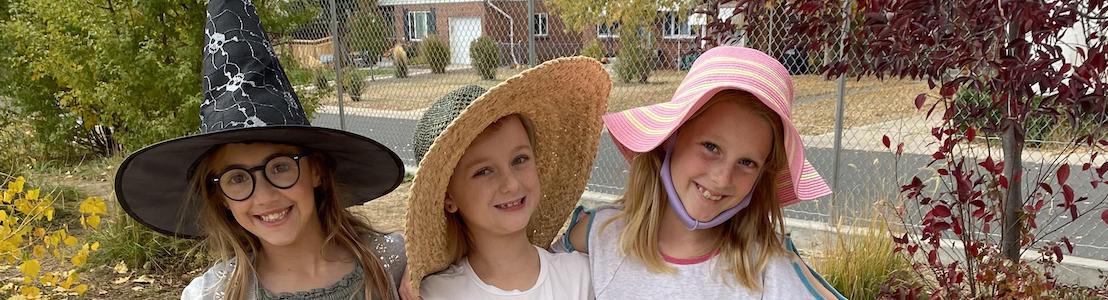 Students posing outside with hats